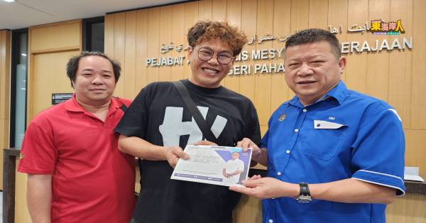 关丹永寿福利协会青年团副团长李憬权（左起）及陈橖贤从沈春祥手中接领彭州政府拨款。