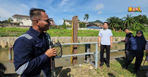 助理工程师莫哈末杰菲利(左)向陈俊广等人讲解水灾预报和预警计划的操作流程。